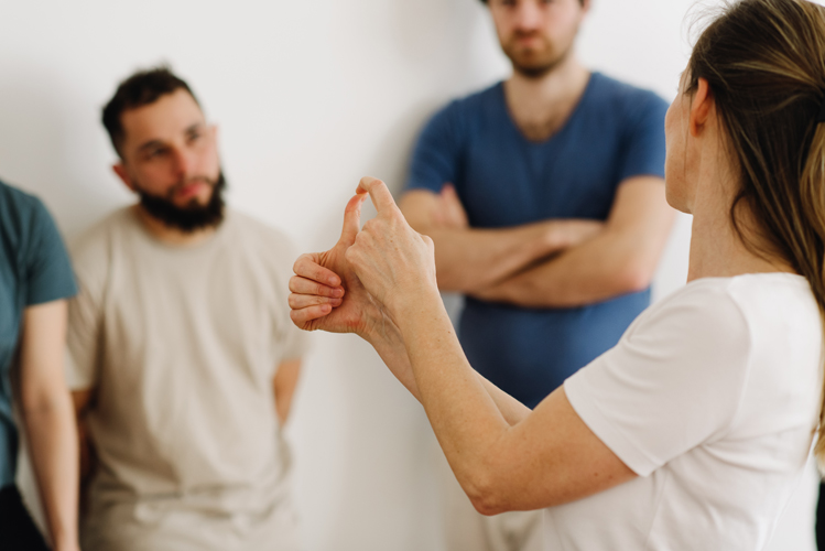 une formatrice démontre comment il ne faut pas tordre ses doigts durant un massage